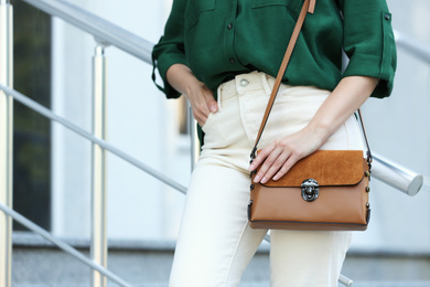 Young woman with stylish leather bag outdoors on summer day, closeup