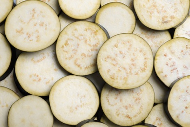 Photo of Slices of raw eggplant as background, top view