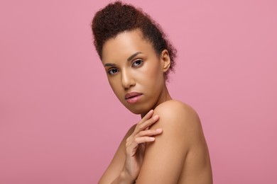 Photo of Portrait of beautiful young woman with glamorous makeup on pink background