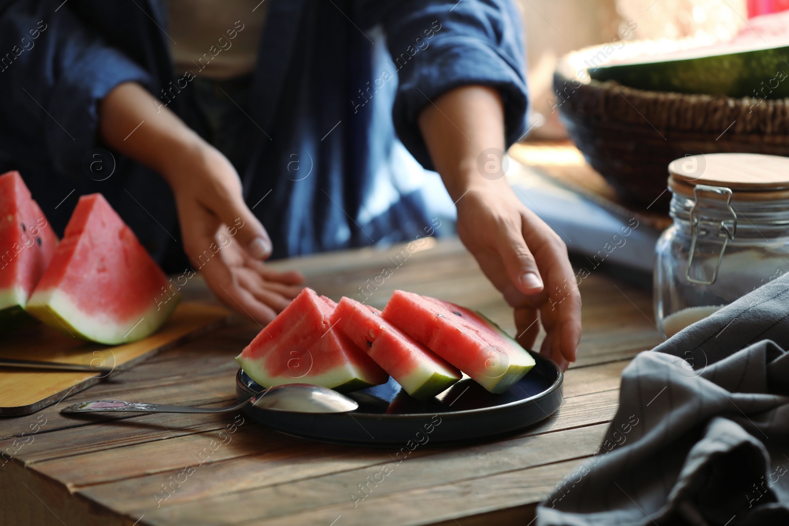 Photo of Woman taking plate with slices of fresh watermelon, closeup