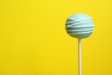 Photo of Bright delicious cake pop on color background. Space for text