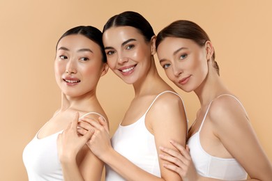 Photo of Beautiful young women with healthy skin on beige background