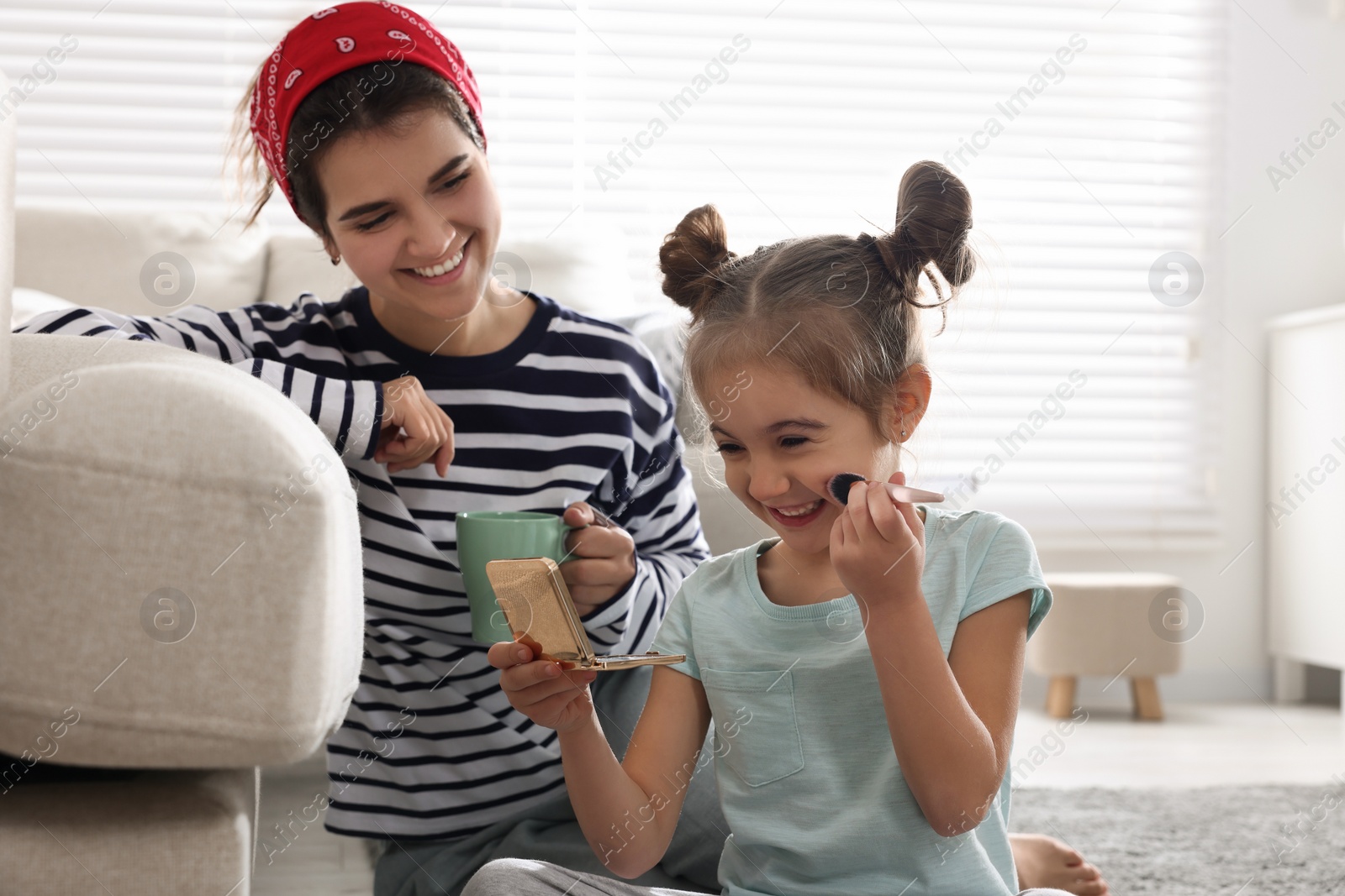 Photo of Young mother and her daughter spending time together at home