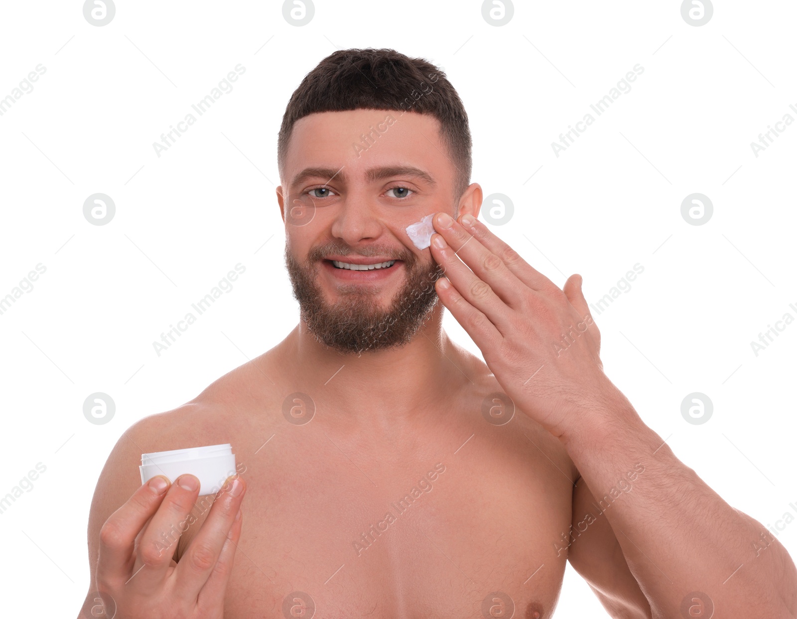 Photo of Handsome man applying cream onto his face on white background