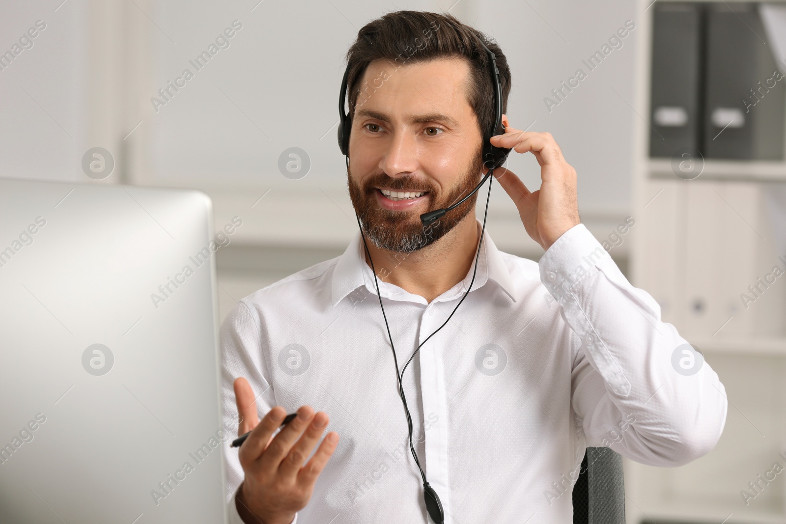 Photo of Hotline operator with headset working in office