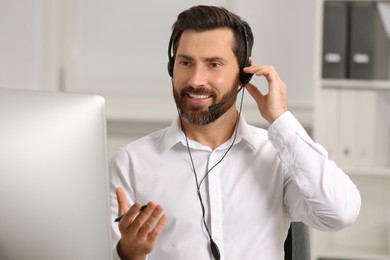 Photo of Hotline operator with headset working in office