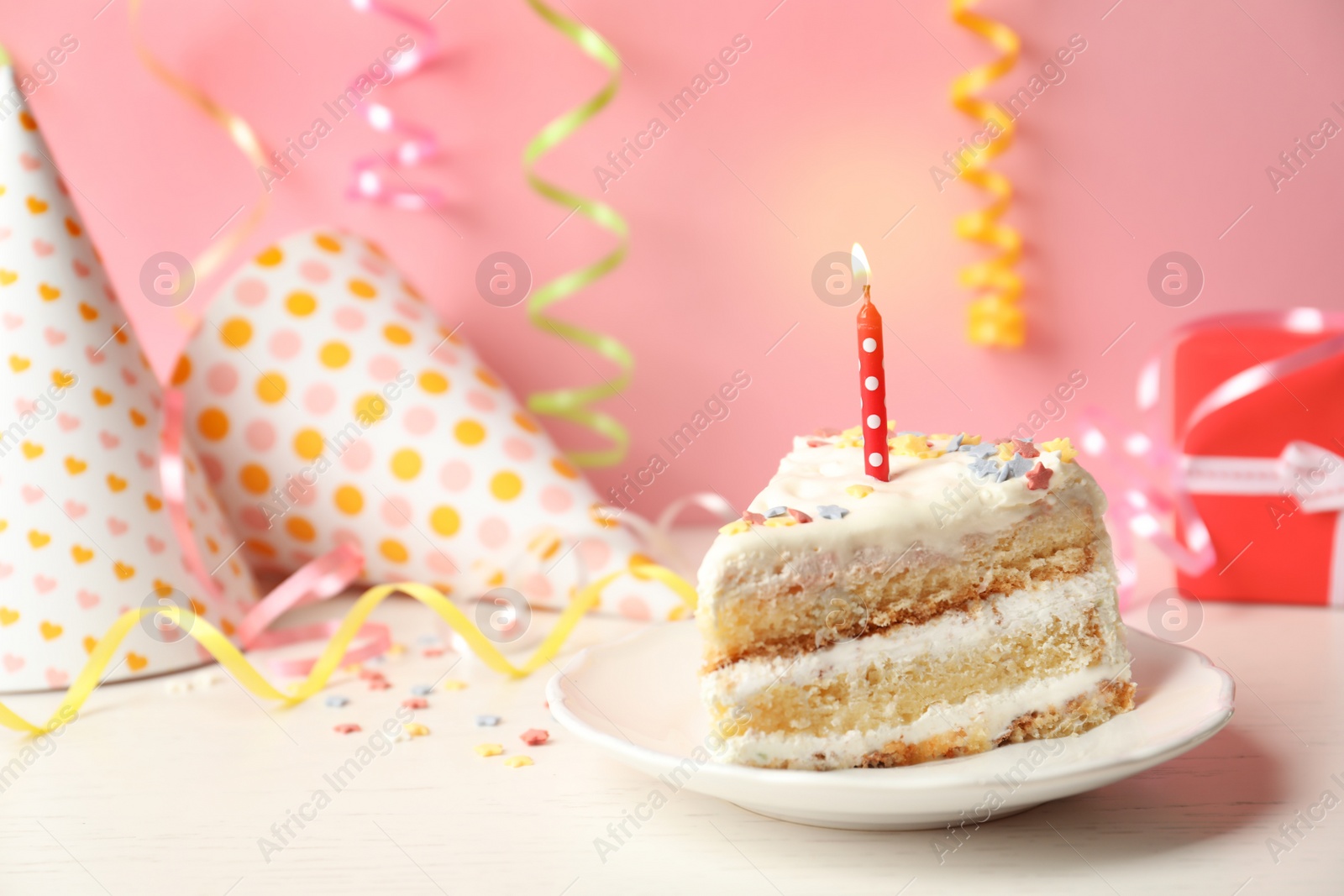 Photo of Slice of delicious birthday cake with candle on table