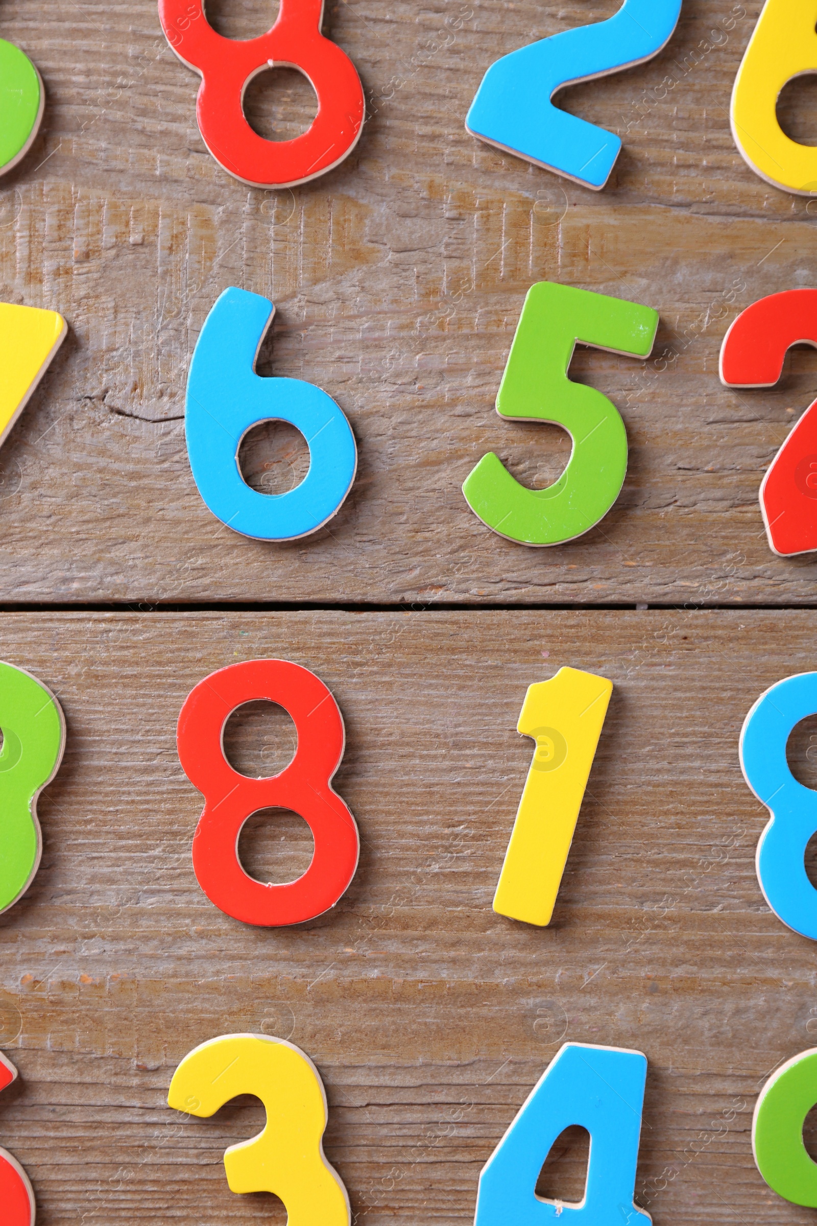 Photo of Colorful numbers on wooden table, flat lay