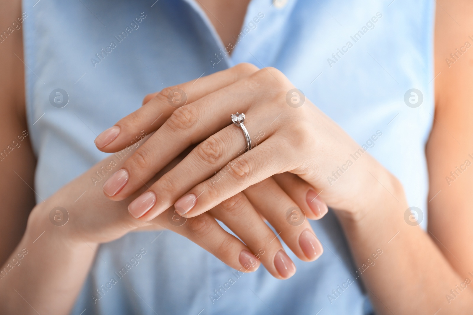 Photo of Young woman wearing beautiful engagement ring, closeup