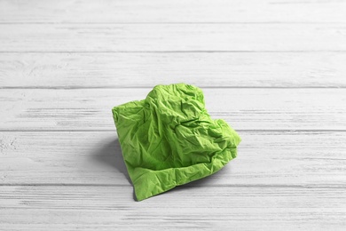 Photo of Crumpled napkin on wooden background. Personal hygiene