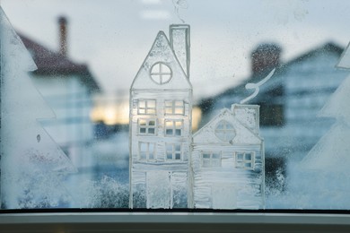 Beautiful drawing made with artificial snow on window. Christmas decor