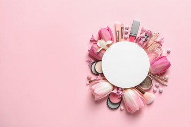 Photo of Makeup products, spring flowers and blank card on color background, flat lay. Space for text