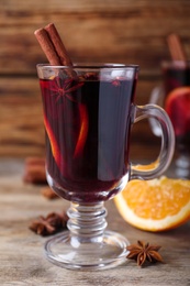 Photo of Delicious red mulled wine on wooden table, closeup