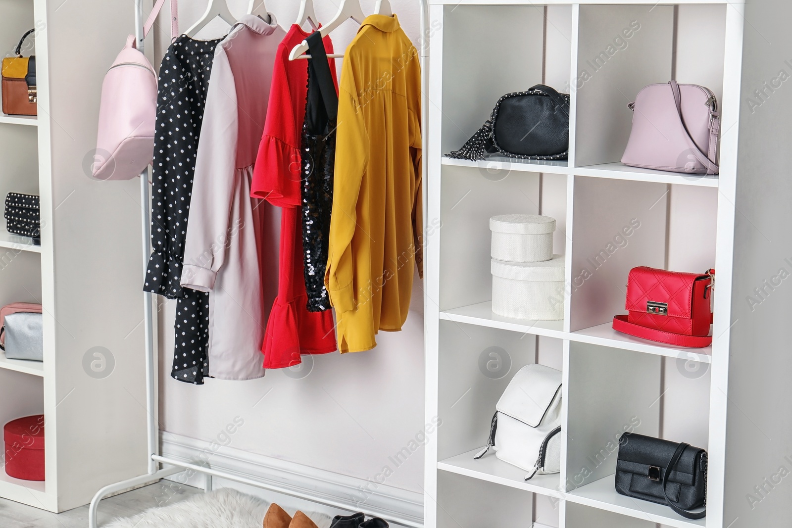 Photo of Wardrobe with stylish bags and clothes indoors. Idea for interior design