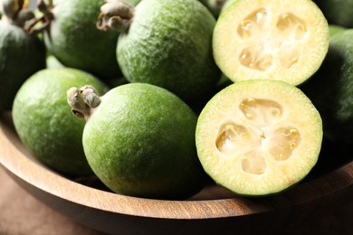 Photo of Plate with delicious fresh feijoas in bowl, closeup