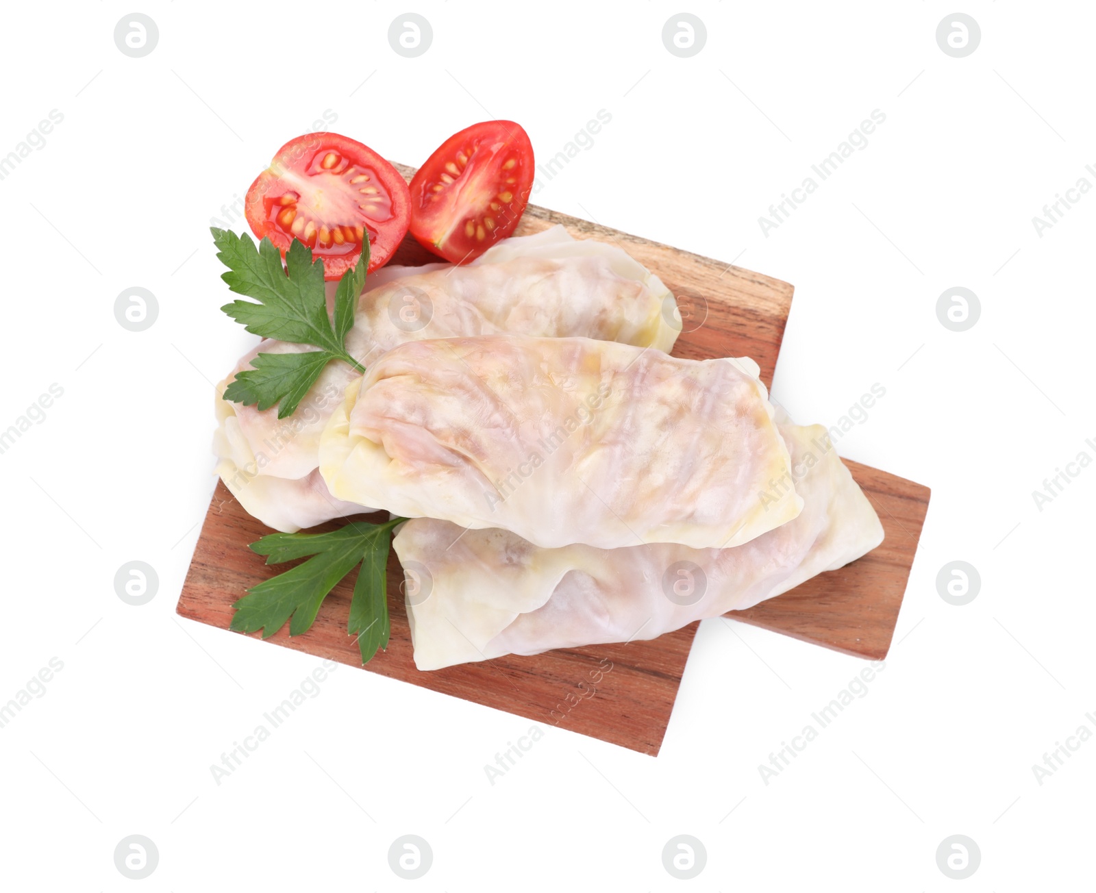 Photo of Wooden board with raw cabbage rolls, tomato and parsley isolated on white, top view