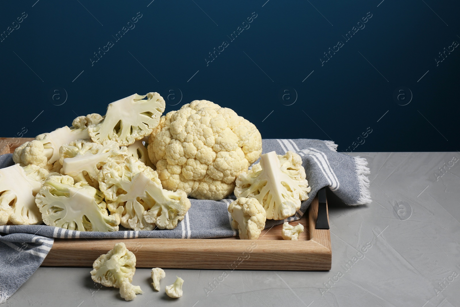 Photo of Fresh raw cauliflower on light grey table. Space for text