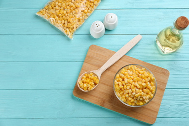 Photo of Flat lay composition with frozen sweet corn on light blue wooden table. Vegetable preservation