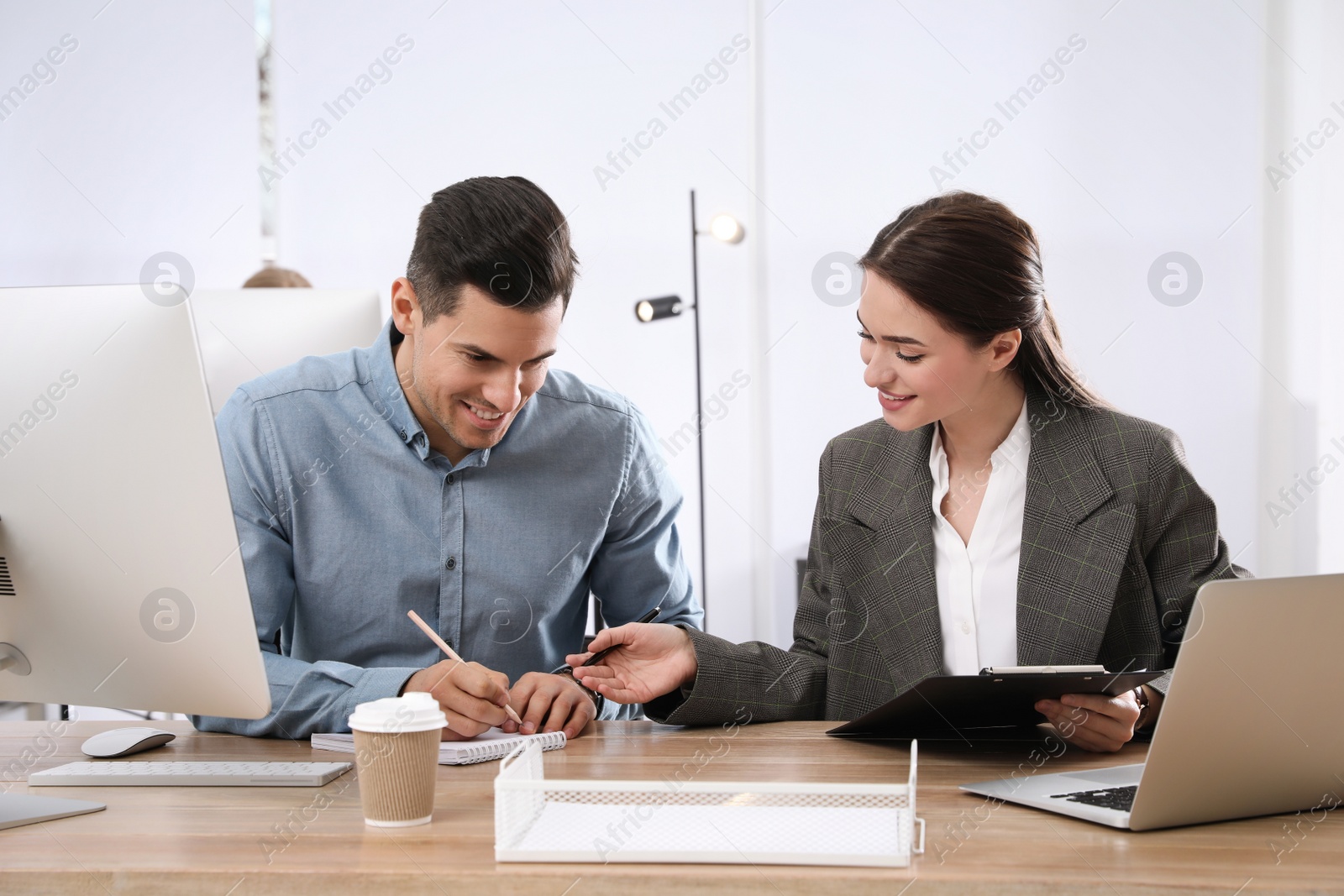 Photo of Businesswoman helping intern with work in office