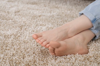 Photo of Woman sitting on soft brown carpet at home, closeup. Space for text