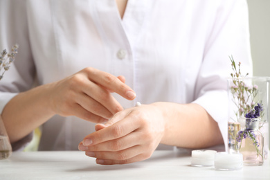 Photo of Scientist testing developed cosmetic product in laboratory, closeup