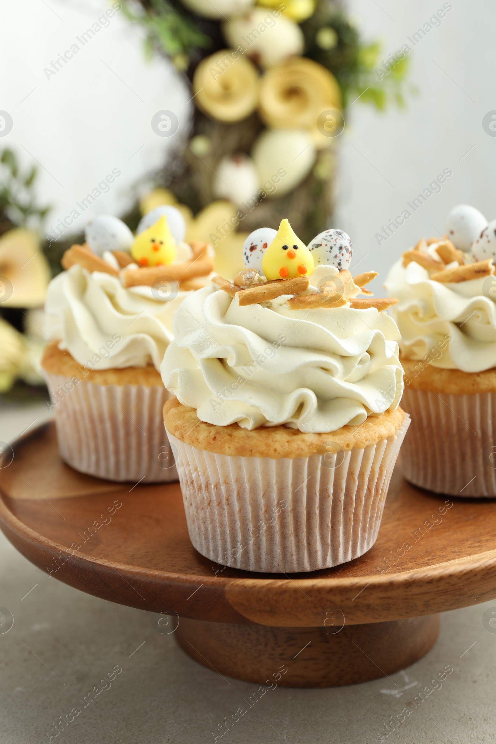 Photo of Tasty Easter cupcakes with vanilla cream on gray table