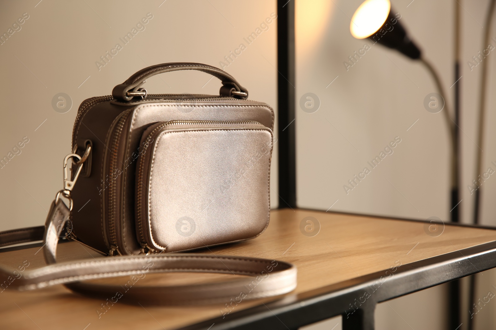 Photo of Elegant grey bag on shelf in luxury boutique