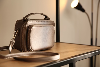 Photo of Elegant grey bag on shelf in luxury boutique