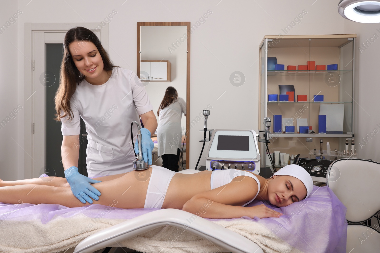 Photo of Young woman undergoing radio frequency lifting procedure in beauty salon