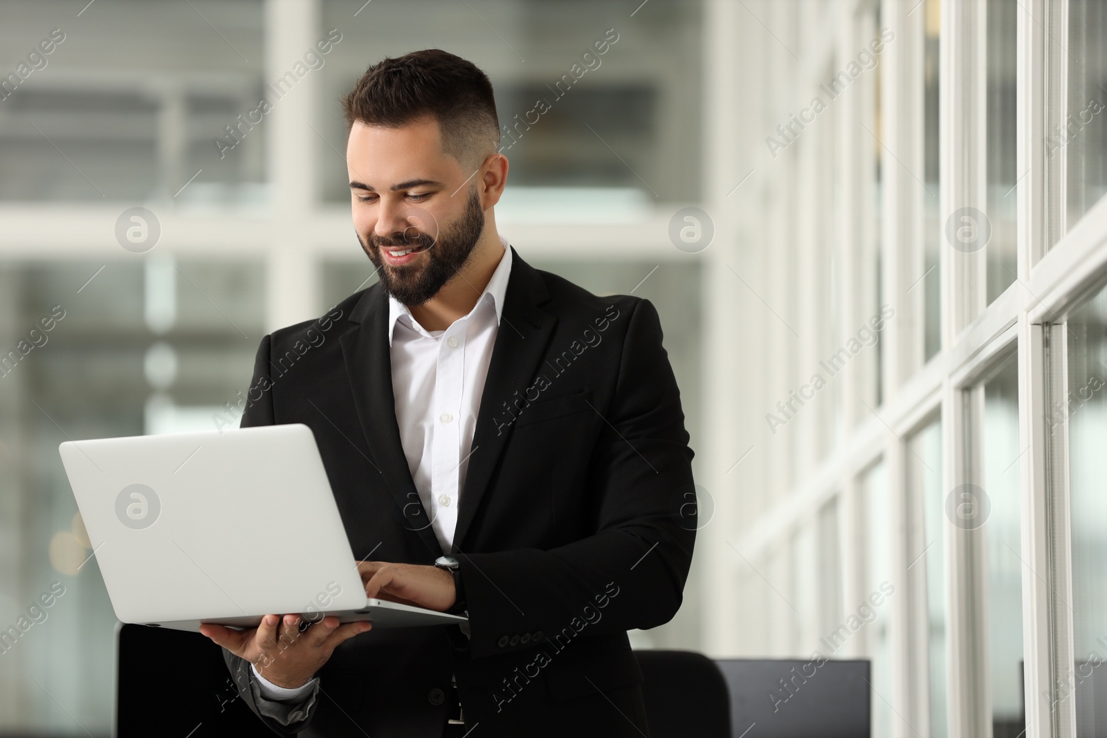 Photo of Smiling man working with laptop in office, space for text. Lawyer, businessman, accountant or manager