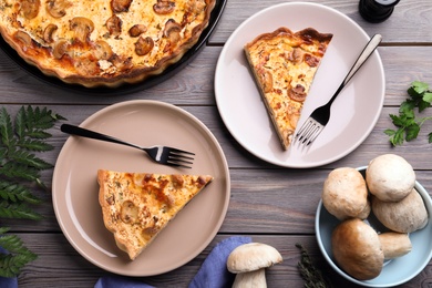 Photo of Delicious pie with mushrooms and cheese served on wooden table, flat lay