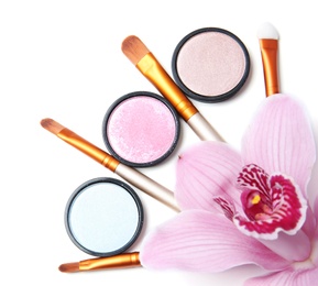 Photo of Makeup brushes with cosmetics and flower on white background