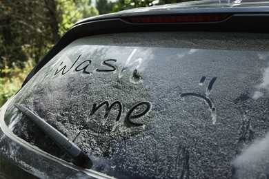 Phrase Wash me written on dirty car window outdoors, closeup