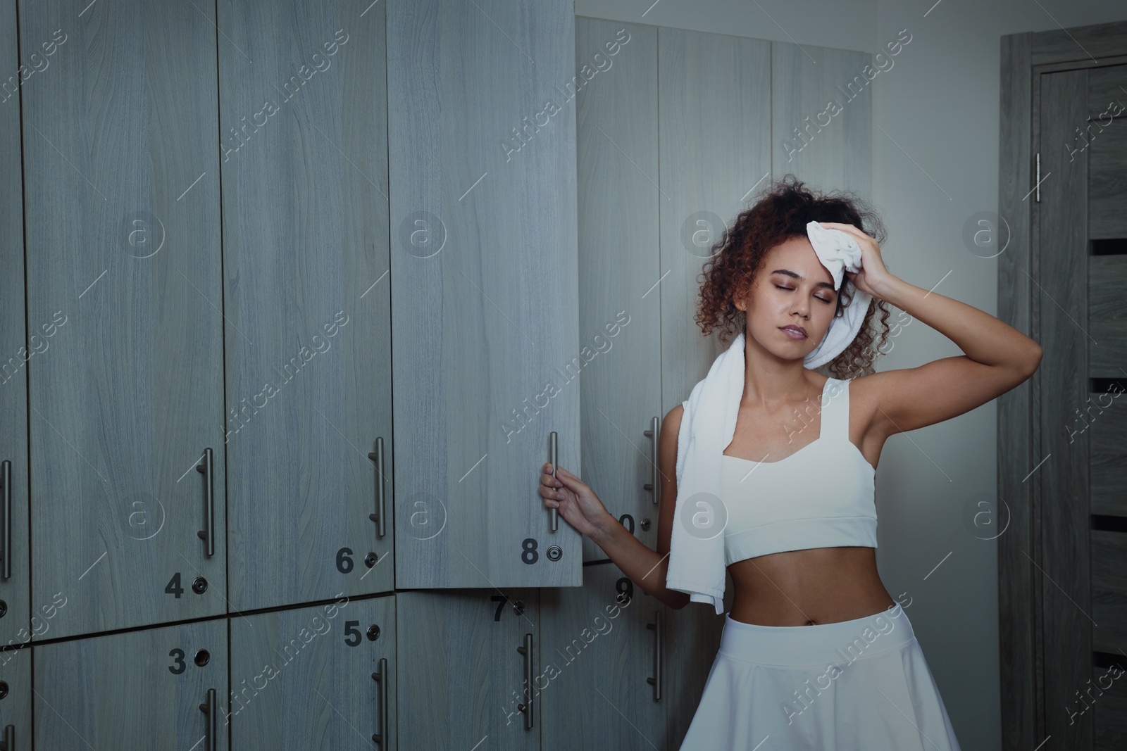 Image of Beautiful tired African American woman after training in locker room