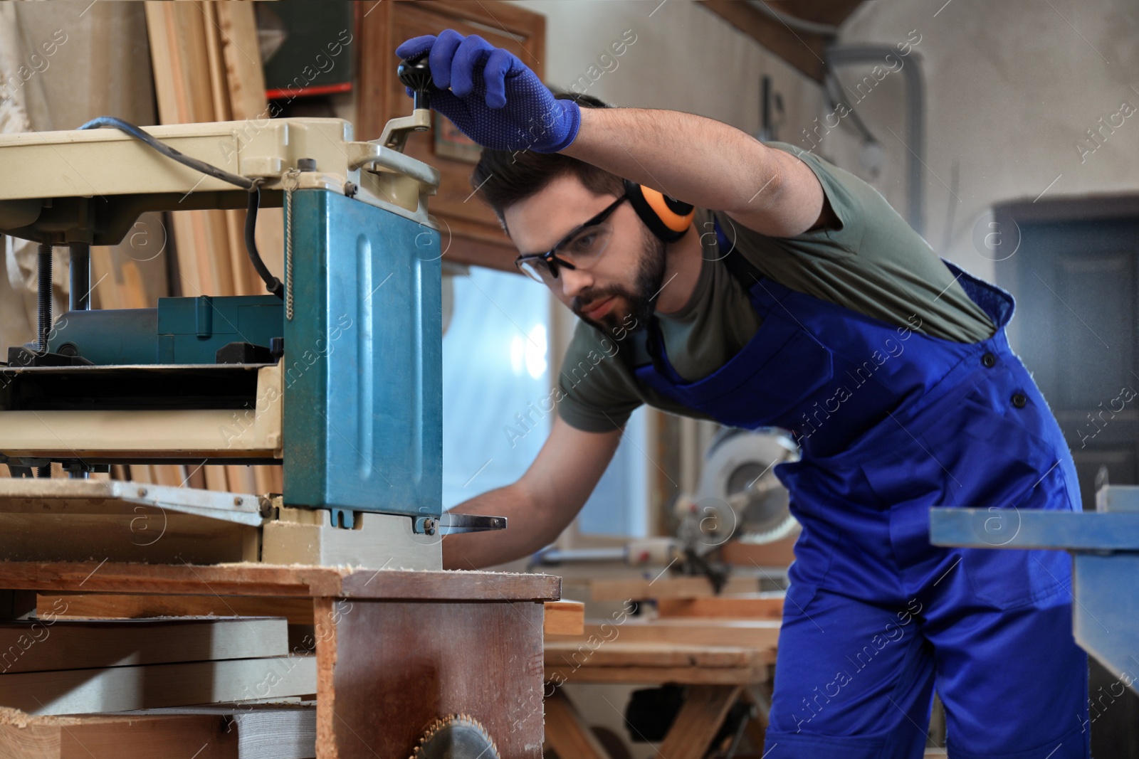 Photo of Professional carpenter working with grinding machine in shop