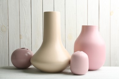 Photo of Stylish ceramic vases on white wooden table