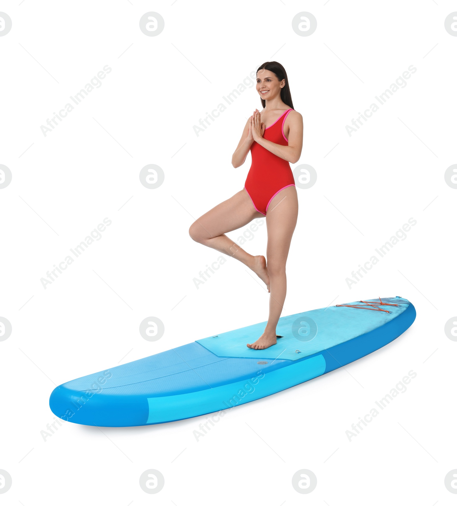 Photo of Happy woman practicing yoga on blue SUP board against white background