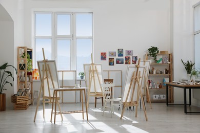 Photo of Stylish artist's studio interior with easels and canvases. Creative hobby