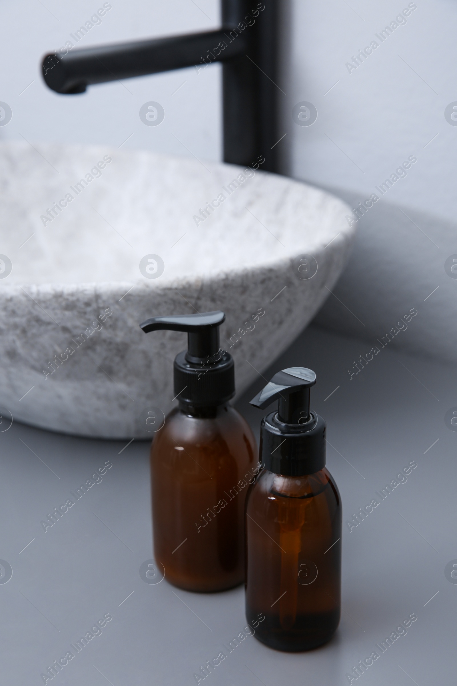 Photo of Dispensers of liquid soap near sink in bathroom