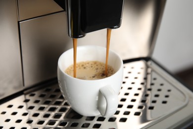 Photo of Espresso machine pouring coffee into cup, closeup