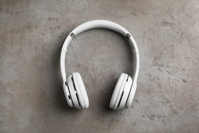 Photo of Stylish modern headphones with earmuffs on gray background, top view