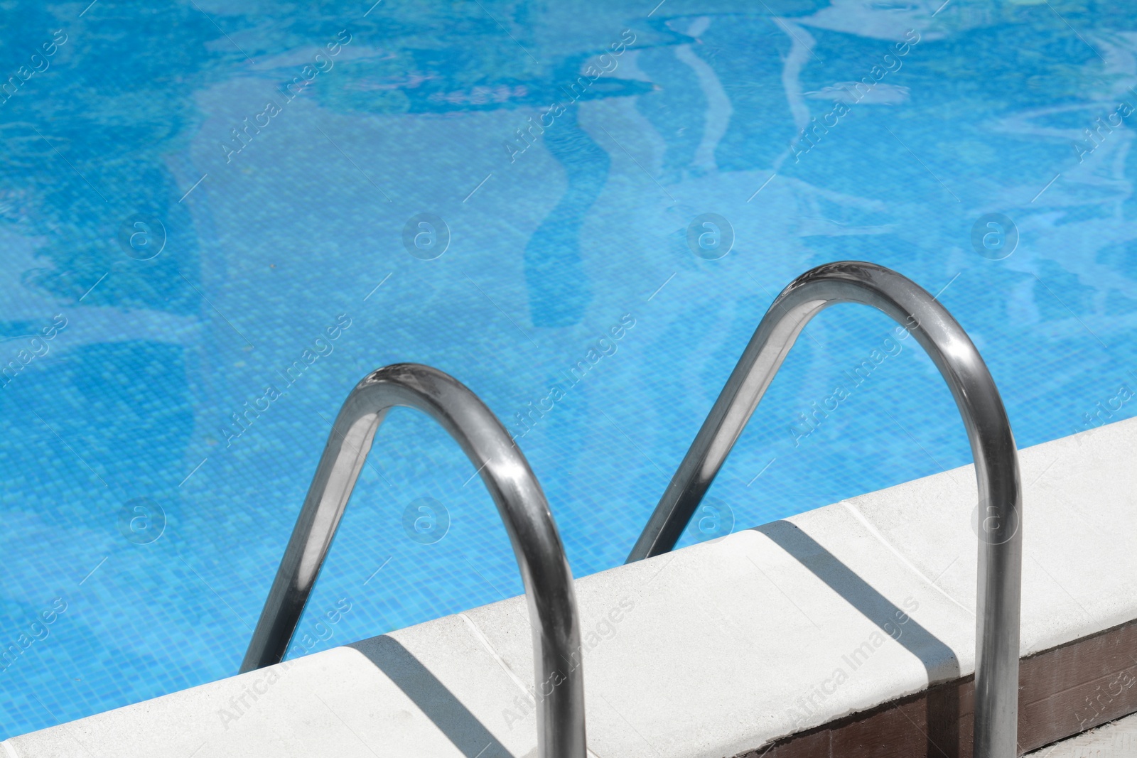 Photo of Swimming pool with metal ladder on sunny day