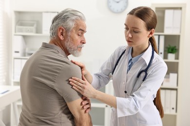 Photo of Arthritis symptoms. Doctor examining patient with shoulder pain in hospital