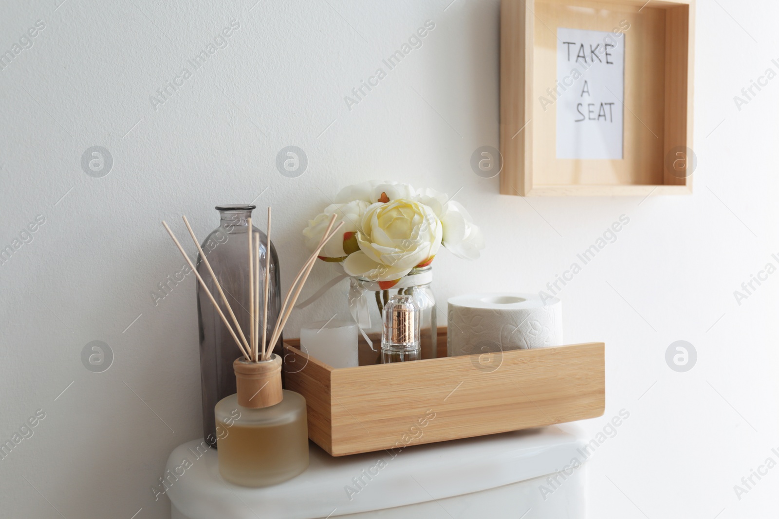 Photo of Decor elements, necessities and toilet bowl near white wall. Bathroom interior