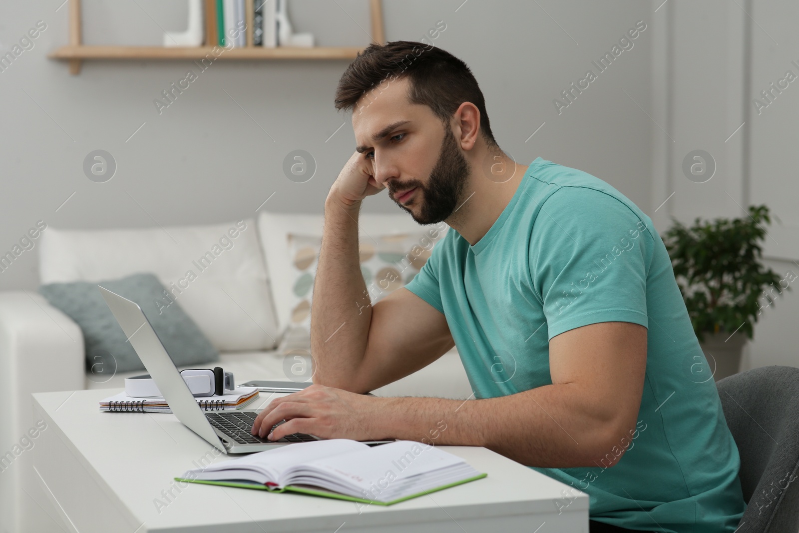 Photo of Online test. Man studying with laptop at home