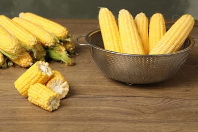 Tasty sweet corn cobs on wooden table