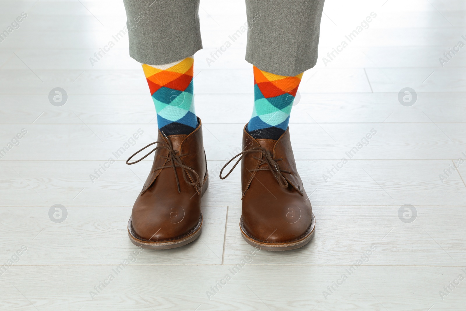 Photo of Man wearing stylish socks and shoes on floor, closeup