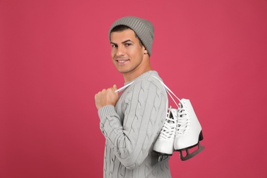 Photo of Happy man with ice skates on pink background