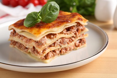 Photo of Delicious cooked lasagna served on wooden table