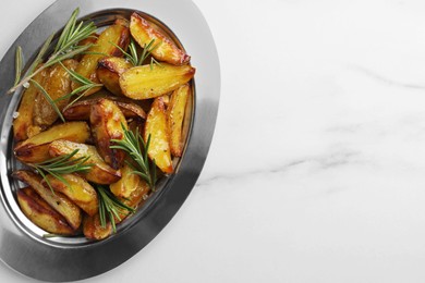 Photo of Plate with tasty baked potato and aromatic rosemary on white marble table, top view. Space for text